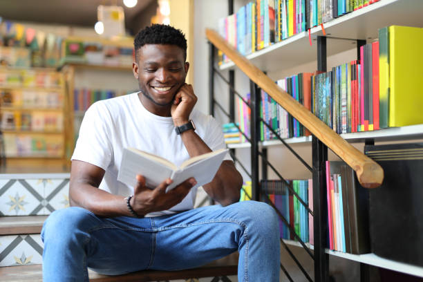 A young student in a library, immersed in reading and studying, exudes academic positivity.