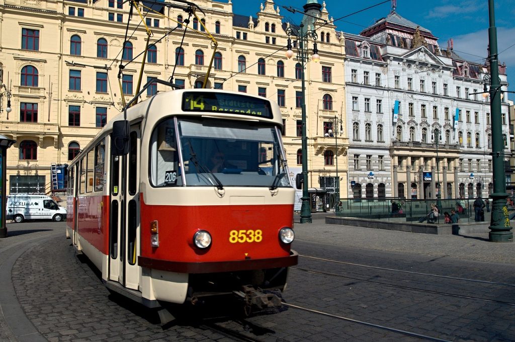 A red and white tram numbered 8538 operating on a city street, with historic ornate buildings in the background and a pedestrian area visible.